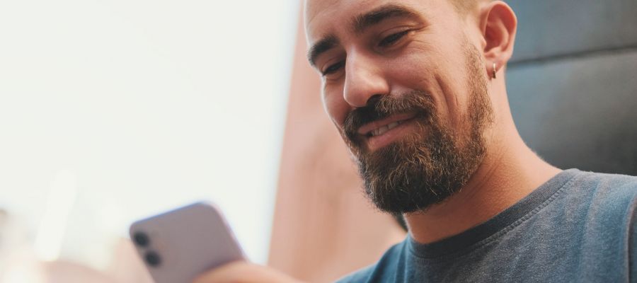 Ein Mann schaut auf sein Smartphone und nutzt digitale Angebote