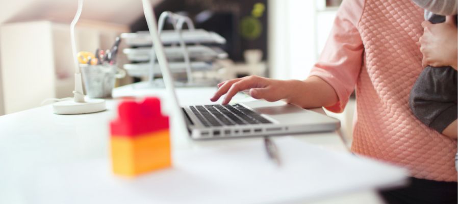 Eine ältere Frau sitzt mit einer jüngeren Frau am Laptop und coacht sie