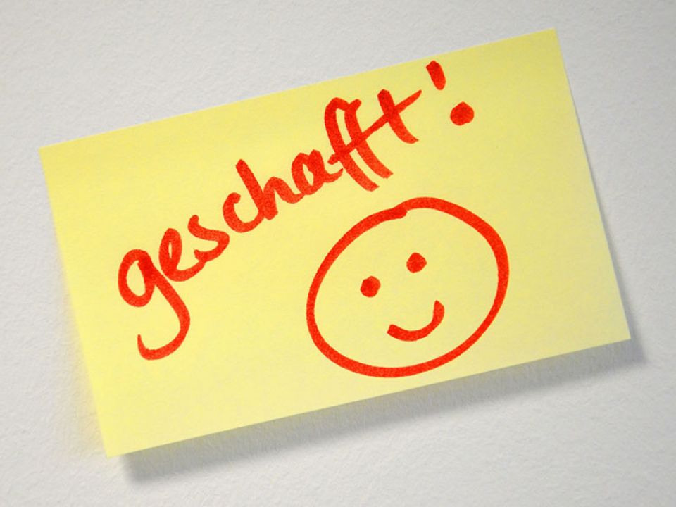 Post-it mit einem Smiley und dem Wort "geschafft!"