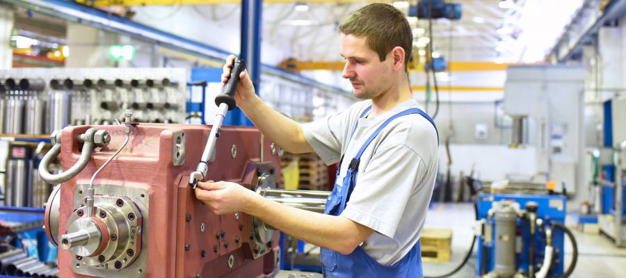 Industriemechaniker zieht Schrauben an einer Maschine fest