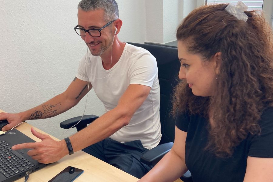Ein Mitarbeiter und eine Mitarbeiterin arbeiten gemeinsam am Computer
